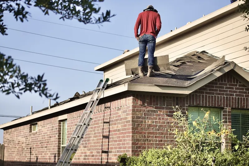 Professional roofer working on a residential roof in Stansell